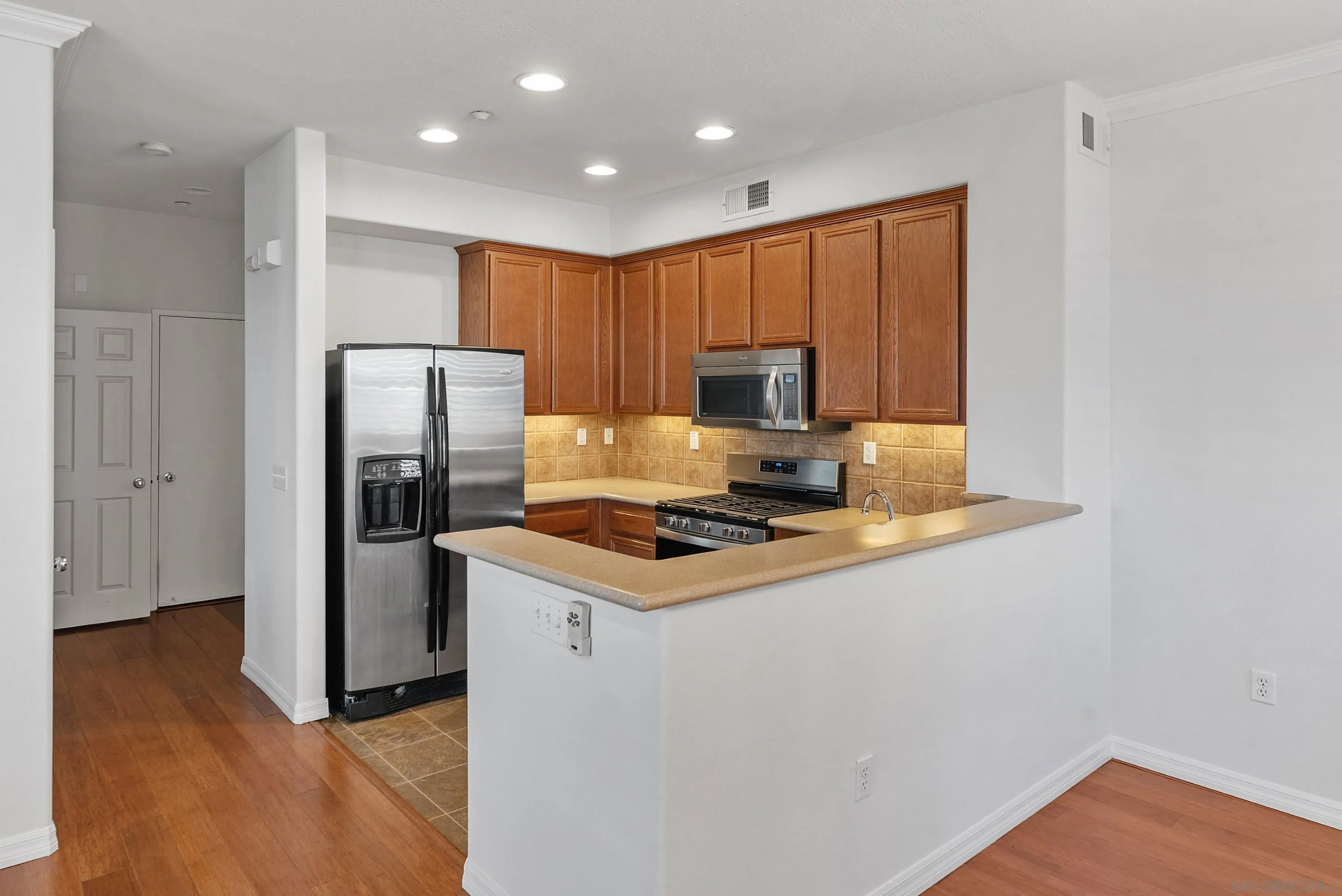 2185 Caminito Rinaldo, Unit 118 Chula Vista, CA 91915 - Photo 9 of 38 a kitchen with a refrigerator a stove and a microwave