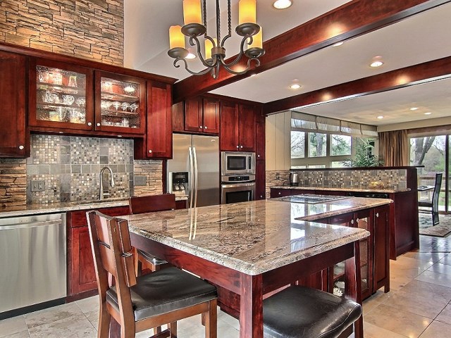 6232 Cunningham Road Rockford, IL 61102 - Photo 8 of 25 a kitchen with stainless steel appliances granite countertop a kitchen island a stove a table and chairs