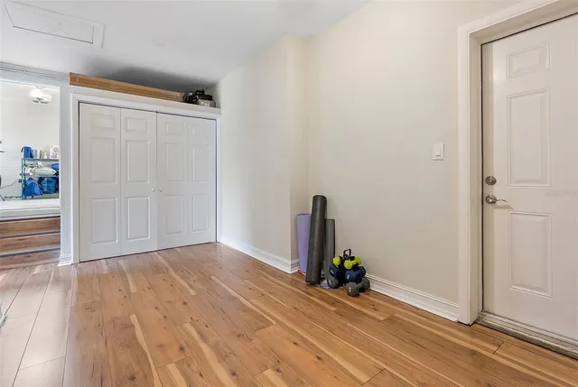 an empty room with wooden floor and a wooden door