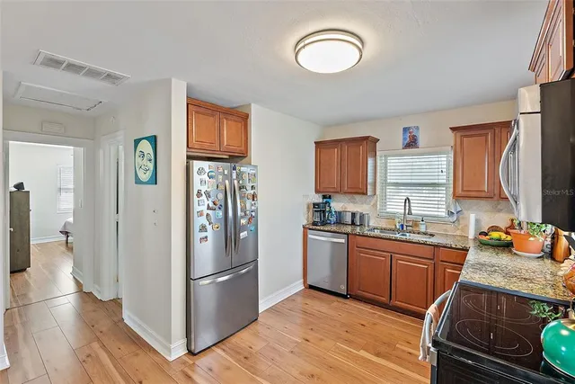 a kitchen with stainless steel appliances granite countertop a refrigerator and a stove