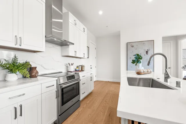 a kitchen with a white stove top oven and white cabinets