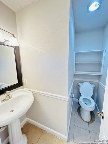 a bathroom with a toilet a sink and a mirror