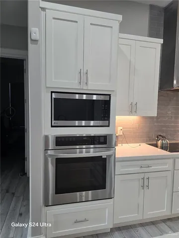 a kitchen with white cabinets and stainless steel appliances