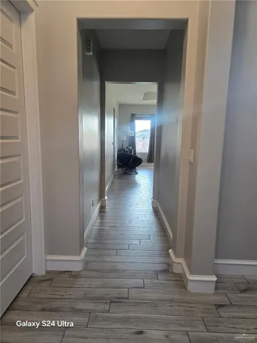 a view of a hallway with wooden floor