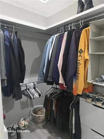 a view of walk in closet with clothes and shoes