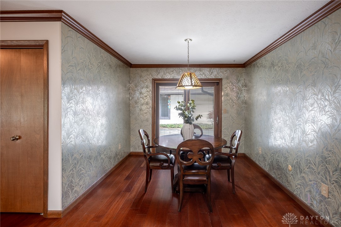 273 North Alpha Bellbrook Road Dayton, OH 45434 - Photo 17 of 43 This dining area features rich wood flooring, elegant wallpaper, and a charming ceiling light fixture.