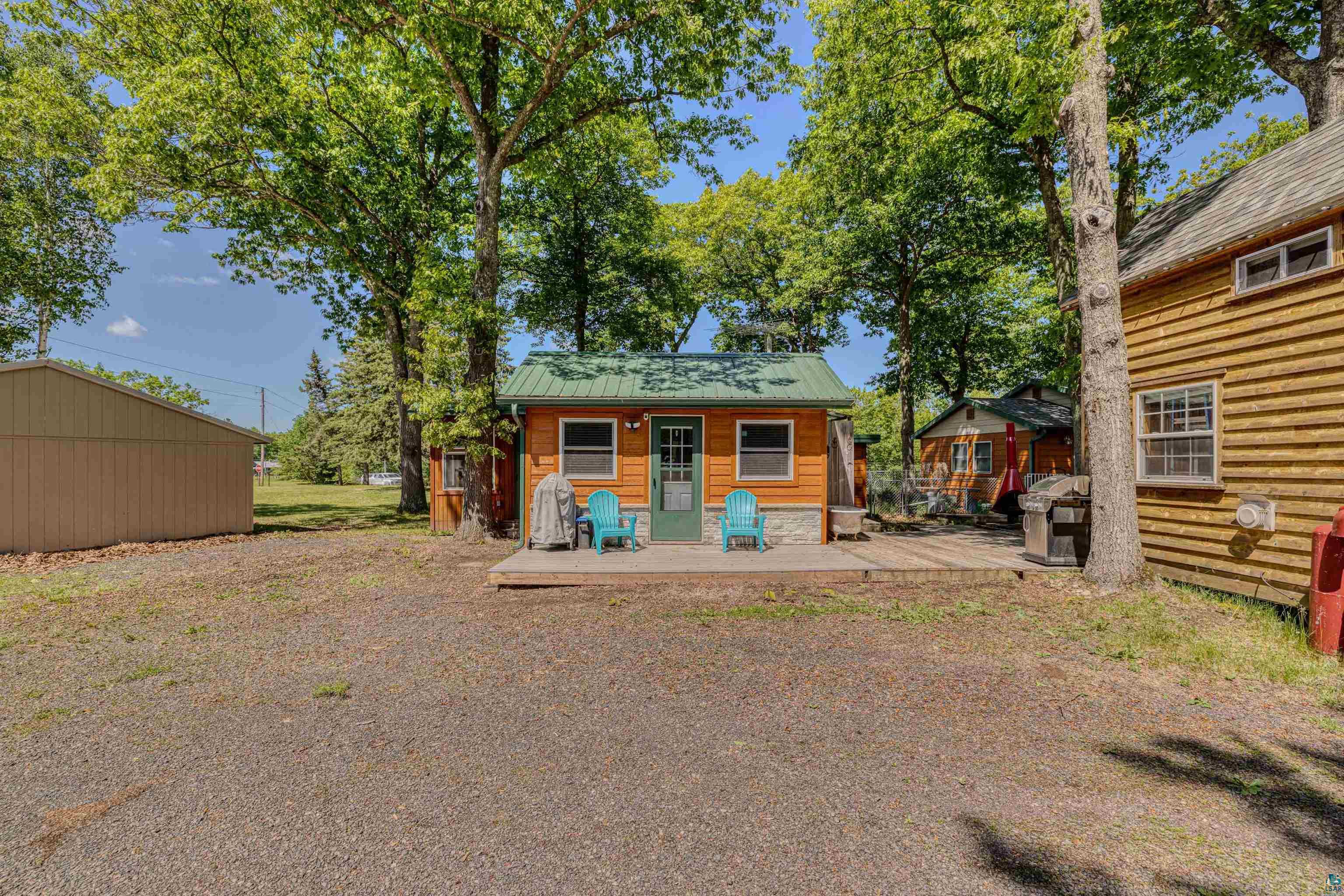 66075 Rooster Road Iron River, WI 54847 - Photo 39 of 52 Small cottage with wood-paneled siding, a green metal roof, and a small porch