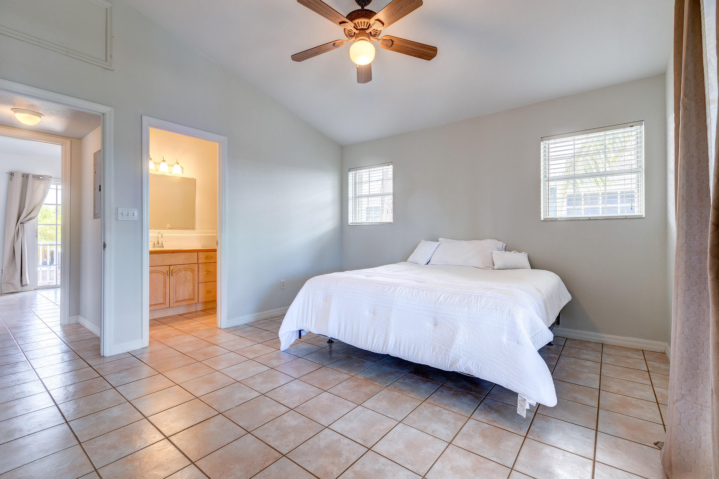 22808 Privateer Drive Cudjoe, FL 33042 - Photo 16 of 28 a bedroom with a bed and a chandelier