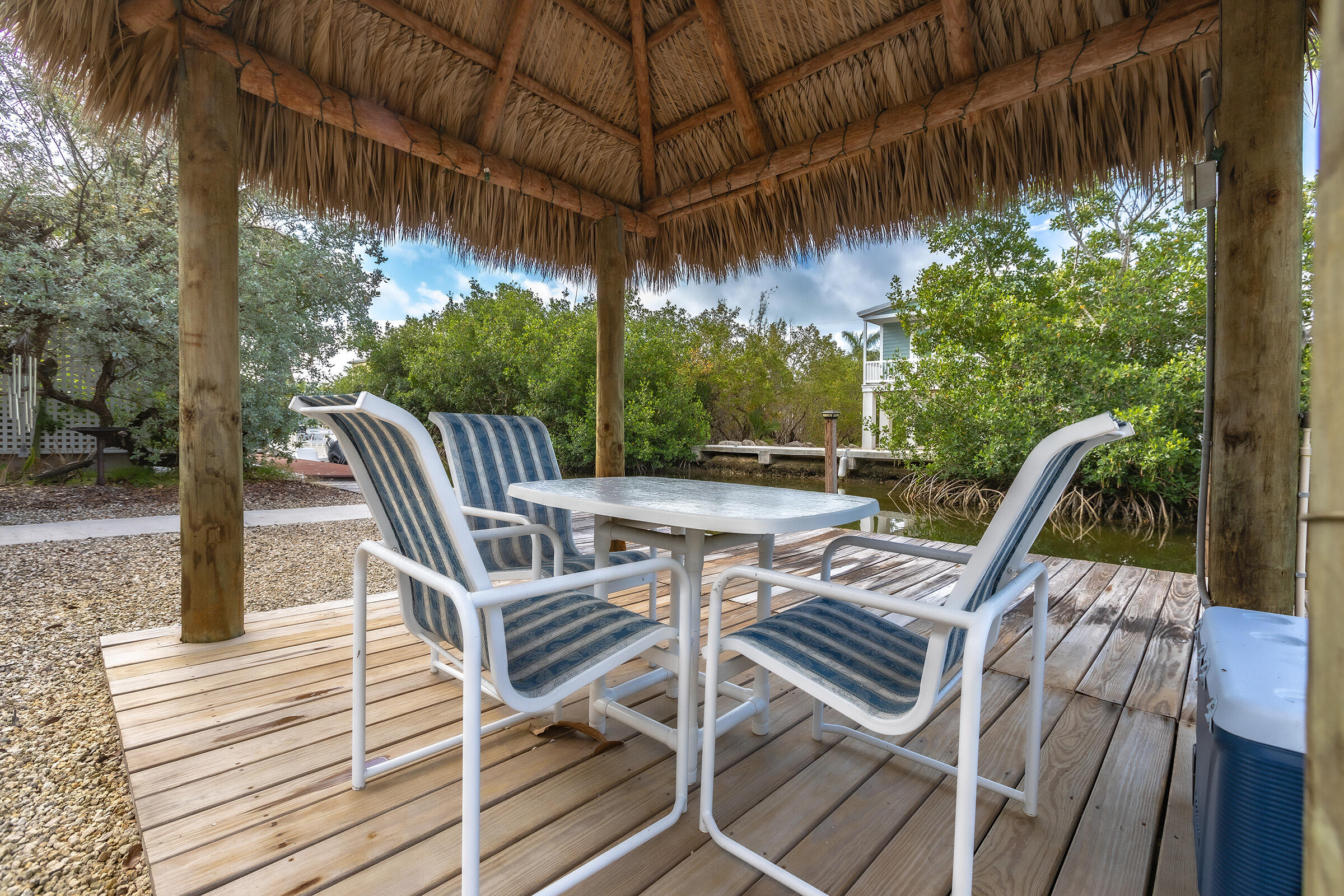 22808 Privateer Drive Cudjoe, FL 33042 - Photo 22 of 28 a view of a patio with table and chairs with wooden floor and fence