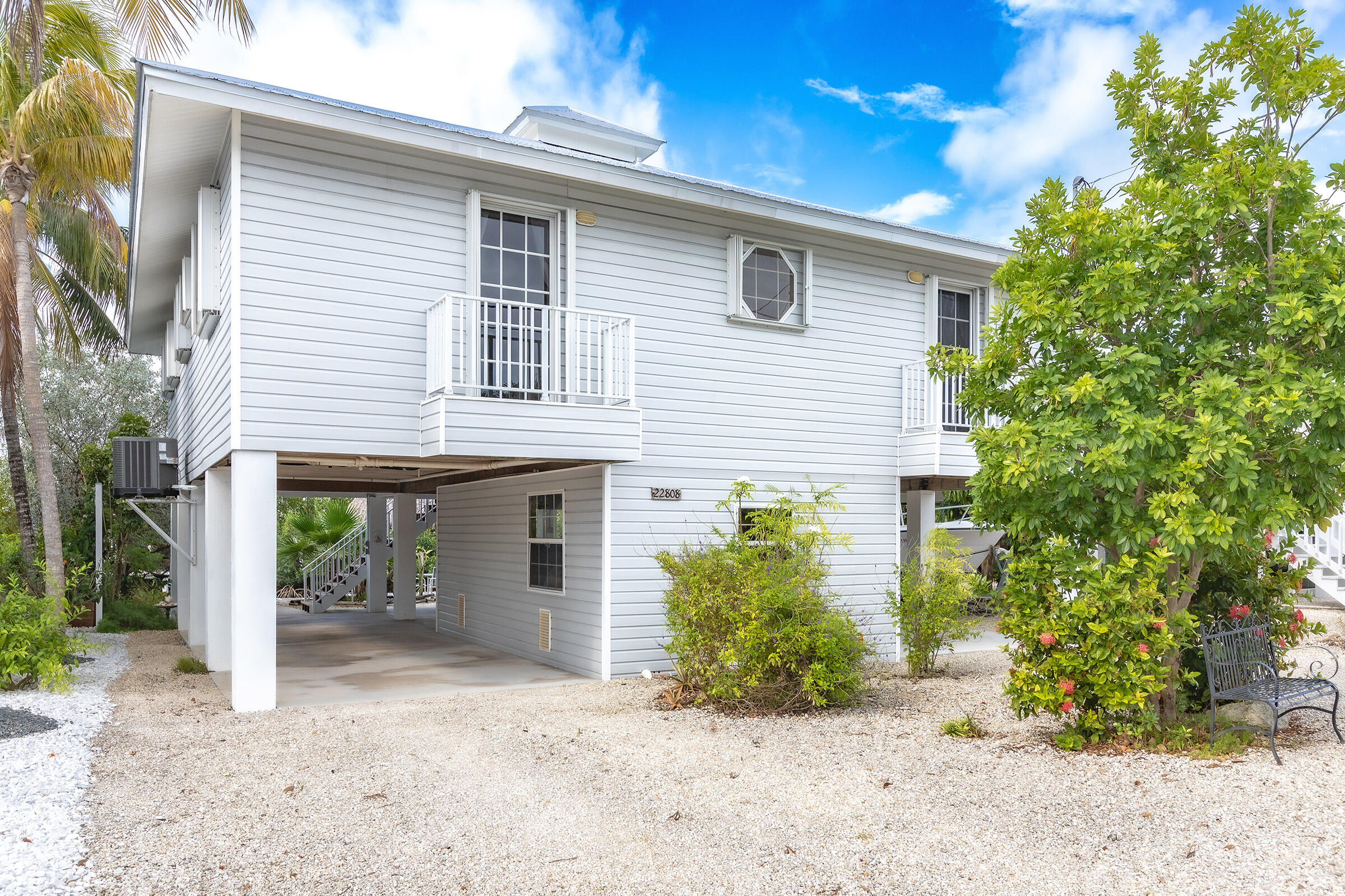22808 Privateer Drive Cudjoe, FL 33042 - Photo 24 of 28 a front view of a house with a yard and a garage