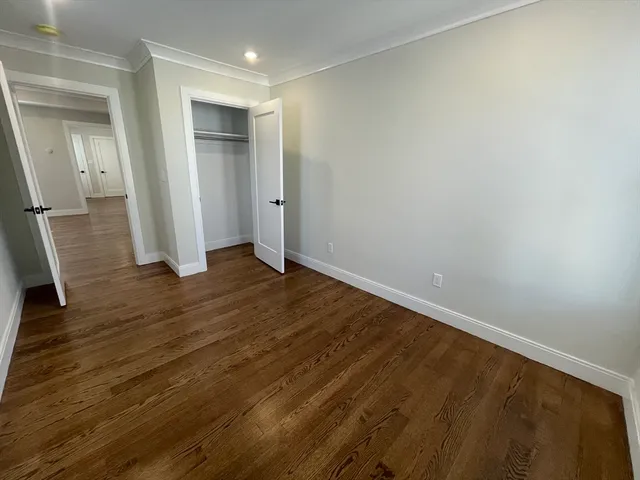 an empty room with wooden floor and entrance