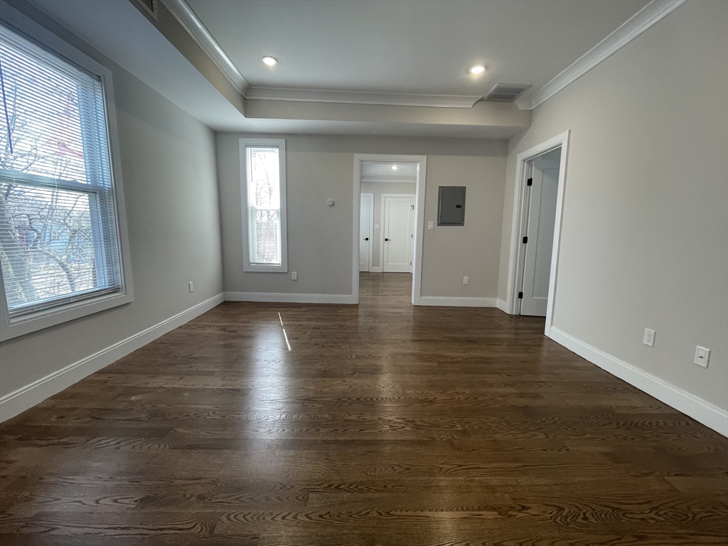 49 Alpine Street, Unit 2 Boston, MA 02119 - Photo 12 of 18 an empty room with wooden floor and windows