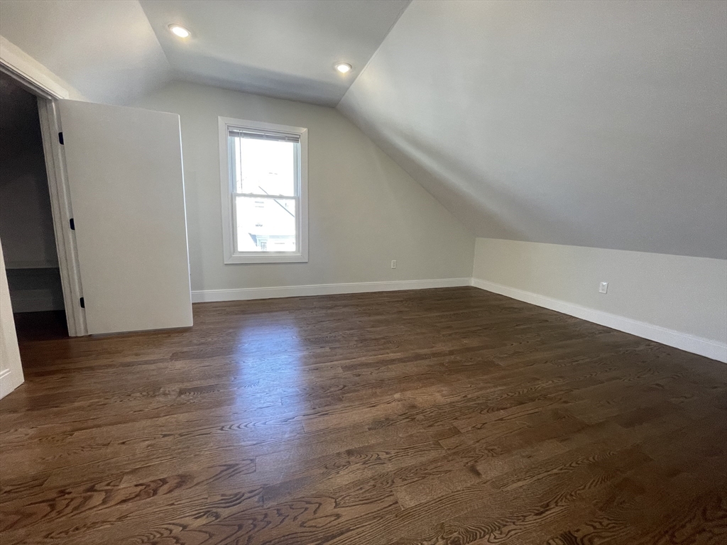 49 Alpine Street, Unit 2 Boston, MA 02119 - Photo 6 of 18 an empty room with wooden floor and windows