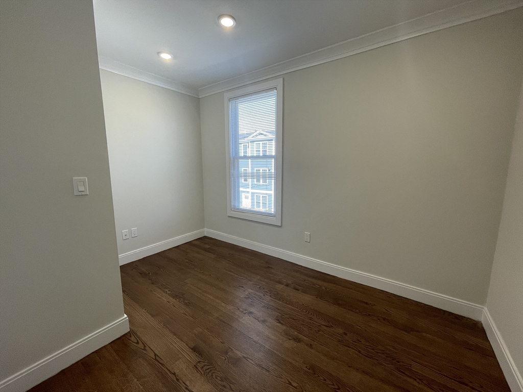 49 Alpine Street, Unit 2 Boston, MA 02119 - Photo 8 of 18 an empty room with wooden floor and windows