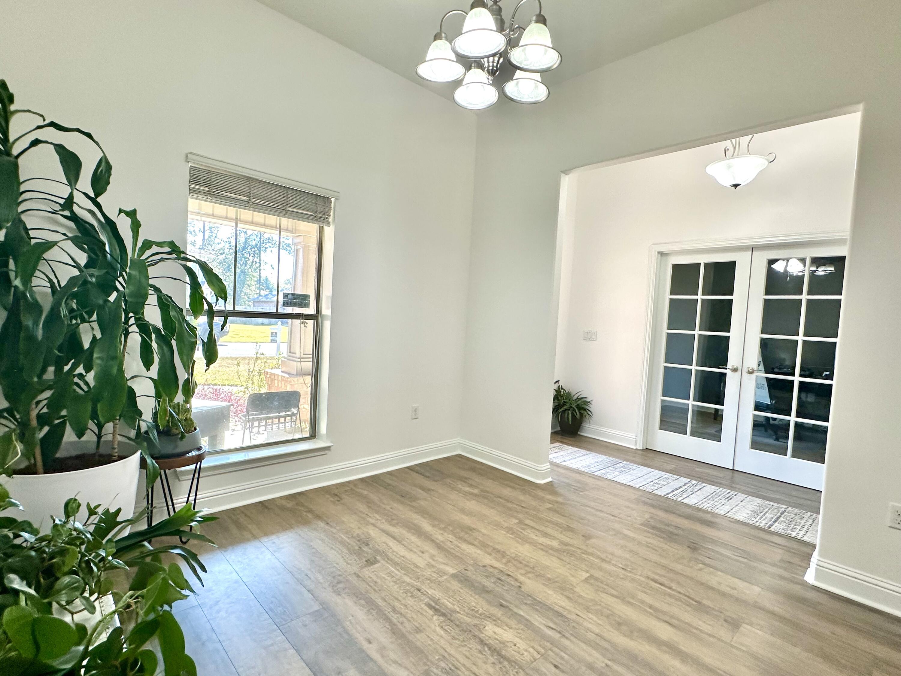 5930 Wind Trace Road Crestview, FL 32536 - Photo 11 of 68 a view of an empty room with a window and wooden floor