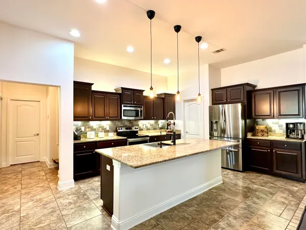 a kitchen with stainless steel appliances granite countertop a sink stove and refrigerator