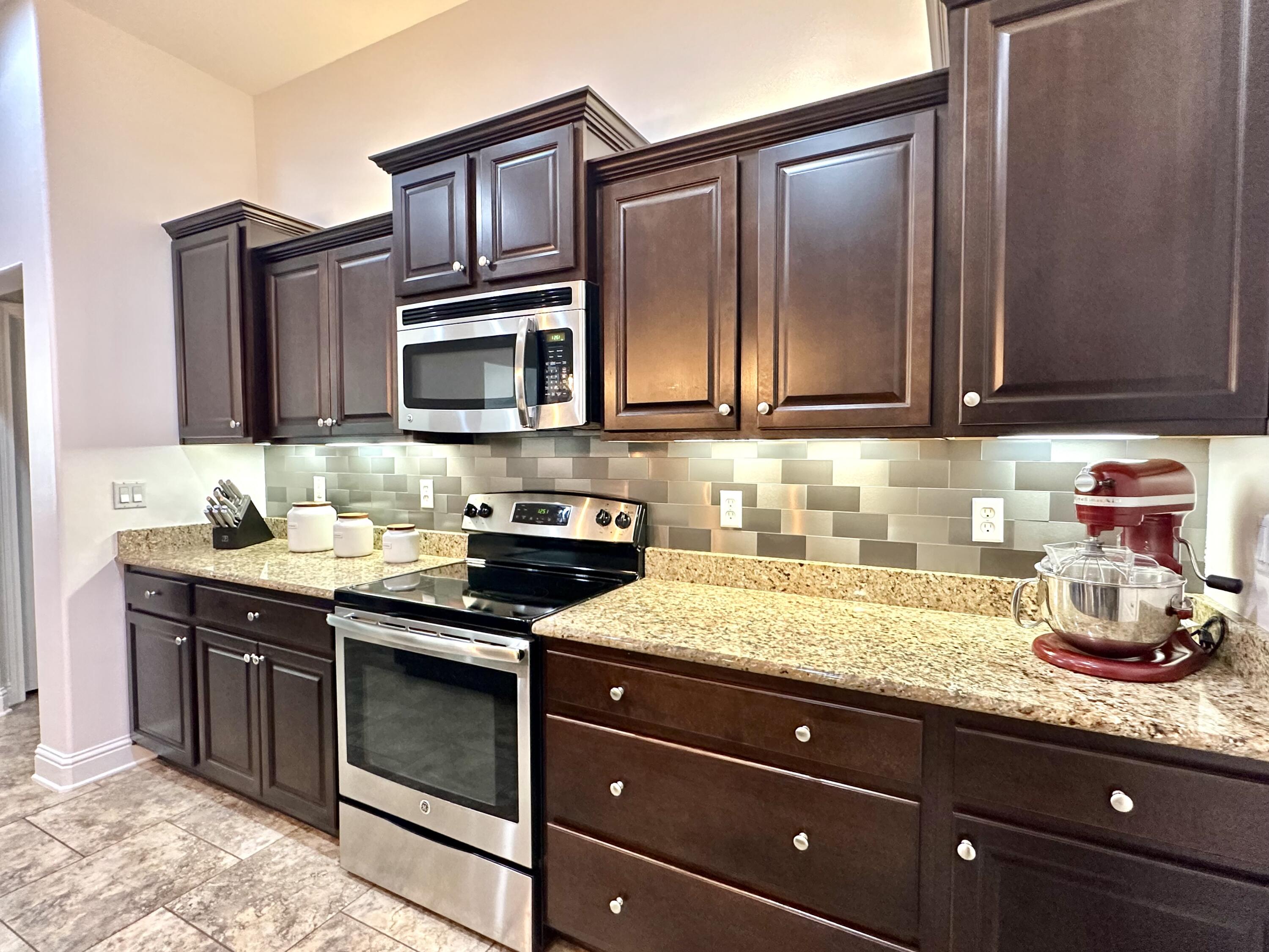 5930 Wind Trace Road Crestview, FL 32536 - Photo 18 of 68 a kitchen with granite countertop stainless steel appliances a stove sink and cabinets