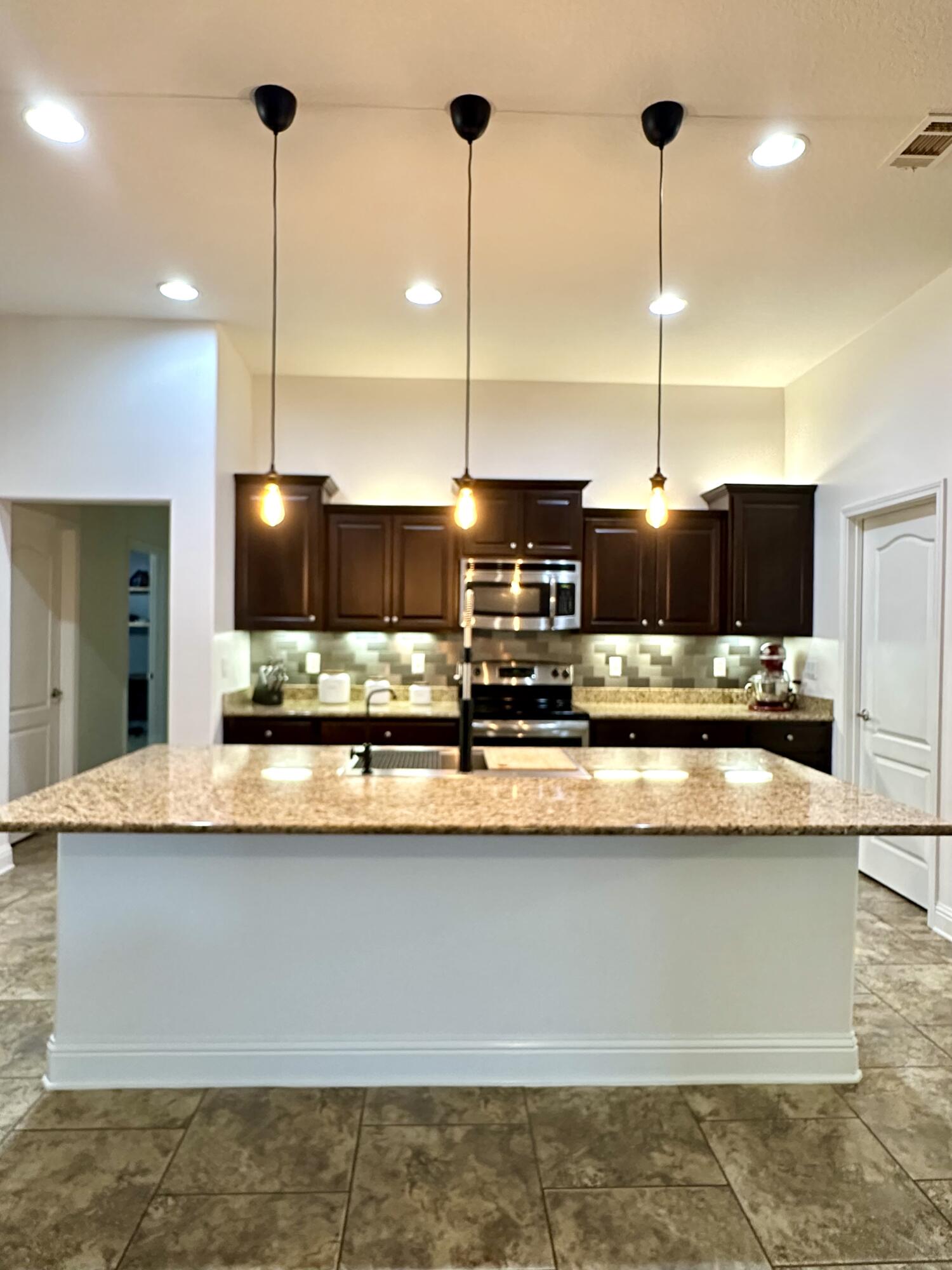 5930 Wind Trace Road Crestview, FL 32536 - Photo 21 of 68 a kitchen with stainless steel appliances granite countertop a sink a stove and a wooden floor