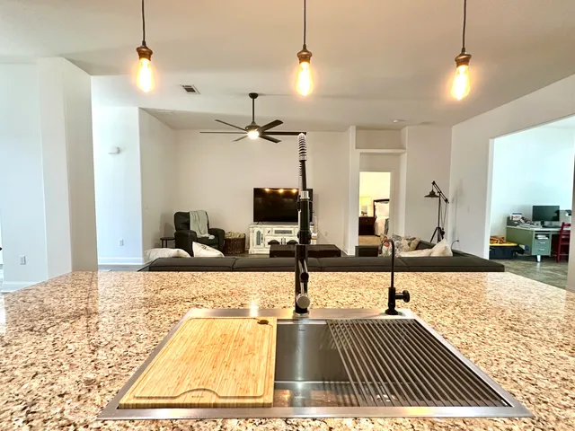 a spacious bathroom with a granite countertop sink a mirror and a shower