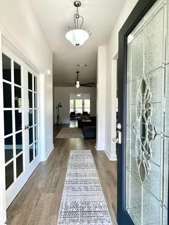 a view of a hallway with wooden floor and windows