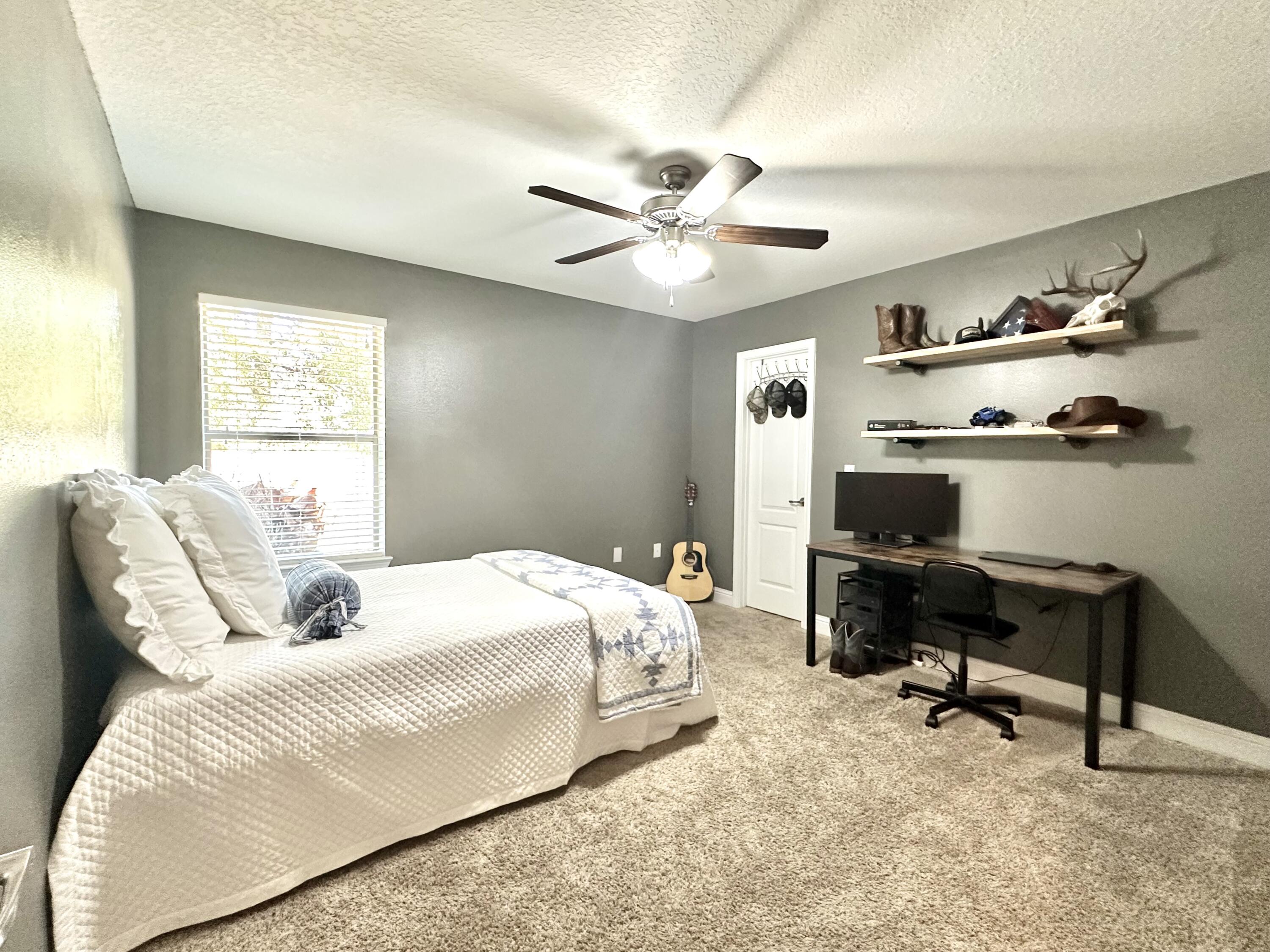 5930 Wind Trace Road Crestview, FL 32536 - Photo 41 of 68 a bedroom with a bed gym equipment and a desk