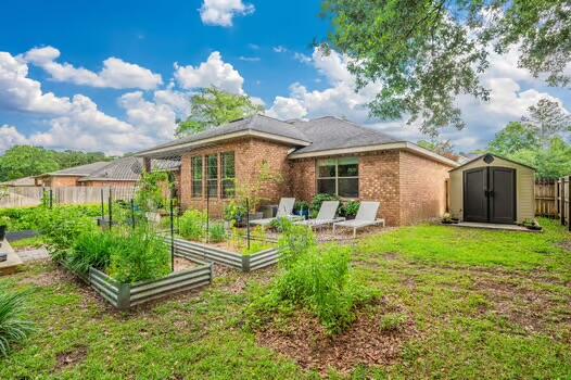 5930 Wind Trace Road Crestview, FL 32536 - Photo 66 of 68 a view of a house with backyard sitting area and garden