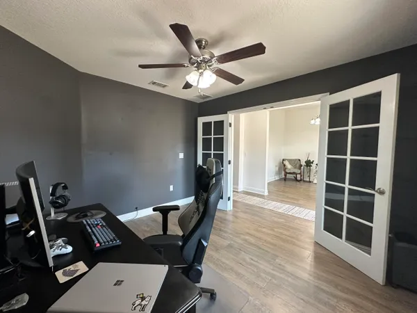 a view of an empty room with a window and wooden floor