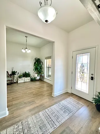 a living room with couches and kitchen view with wooden floor