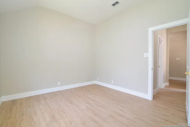 a view of an empty room with wooden floor