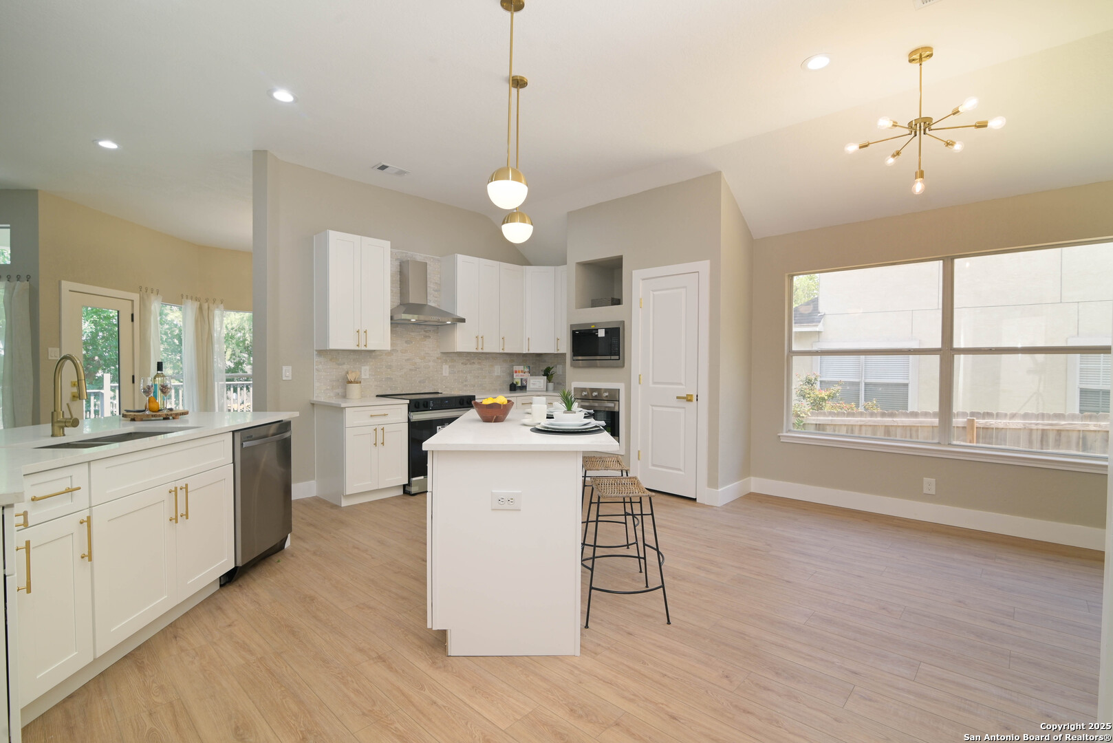 2155 North Ranch Estates Boulevard New Braunfels, TX 78130 - Photo 8 of 28 a kitchen with stainless steel appliances granite countertop a stove top oven a sink a refrigerator and white cabinets with wooden floor