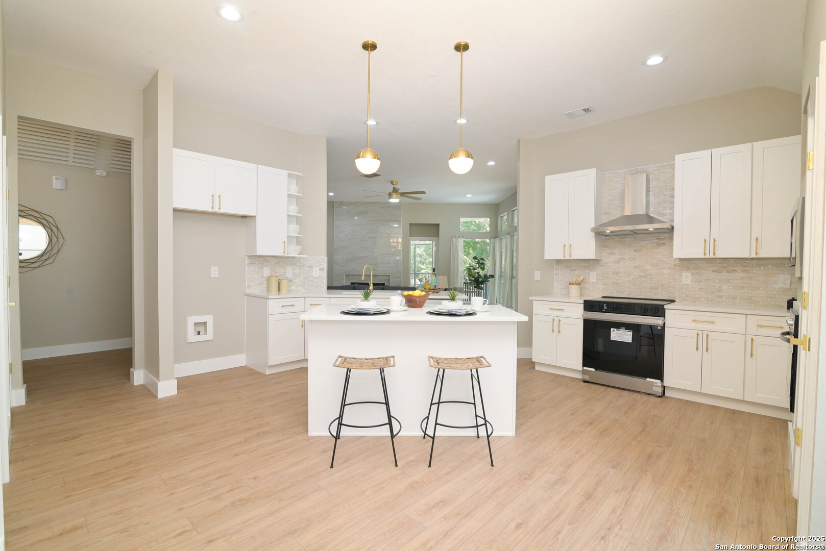 2155 North Ranch Estates Boulevard New Braunfels, TX 78130 - Photo 9 of 28 an open kitchen with granite countertop a stove a sink a refrigerator and white cabinets with wooden floor