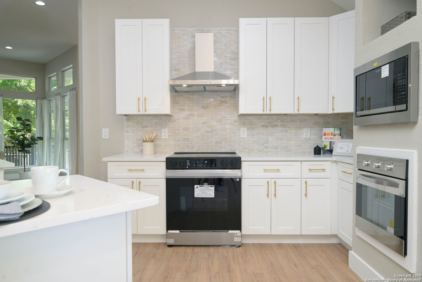 2155 North Ranch Estates Boulevard New Braunfels, TX 78130 - Photo 10 of 28 a kitchen with stainless steel appliances granite countertop a stove a sink and white cabinets