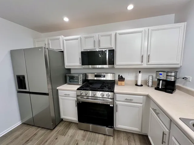 a kitchen with stainless steel appliances granite countertop a sink refrigerator and microwave