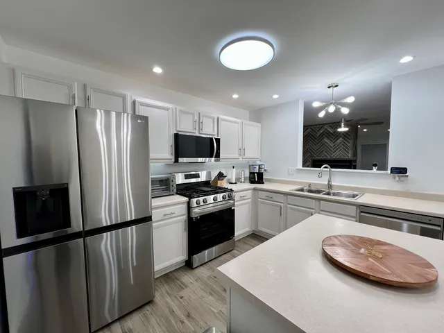 a kitchen with stainless steel appliances a refrigerator stove and microwave