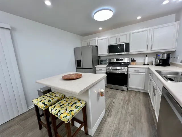 a kitchen with stainless steel appliances granite countertop a sink refrigerator and microwave