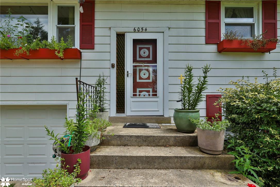 6054 Old Hickory Road Coopersburg, PA 18036 - Photo 2 of 48 Concrete steps lead up to a classic entry door framed by horizontal siding.