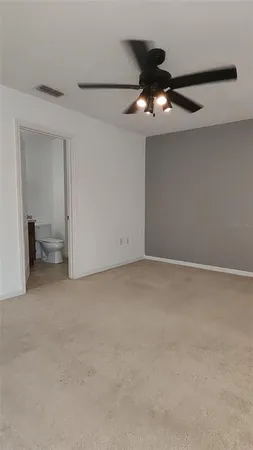a view of an empty room with a ceiling fan