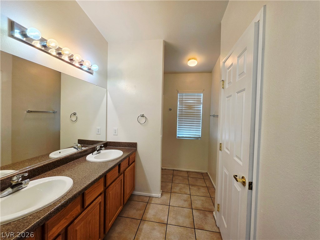 1571 Rusty Ridge Lane Henderson, NV 89002 - Photo 16 of 26 A well-lit bathroom provides ample counter space and dual sinks for convenience.