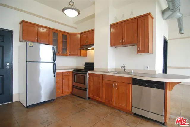 a kitchen with stainless steel appliances granite countertop a refrigerator a sink and a stove