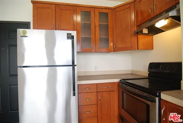 a kitchen with stainless steel appliances granite countertop a refrigerator and a stove top oven