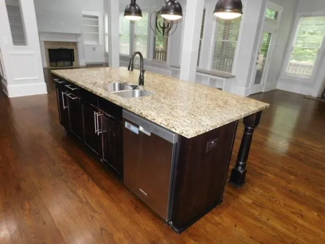 a kitchen with granite countertop sink stove and cabinets
