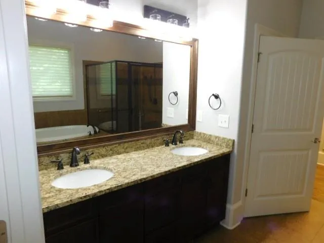 a bathroom with a granite countertop sink and a mirror