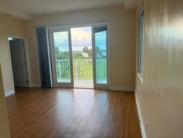 a view of a room with wooden floor and a window