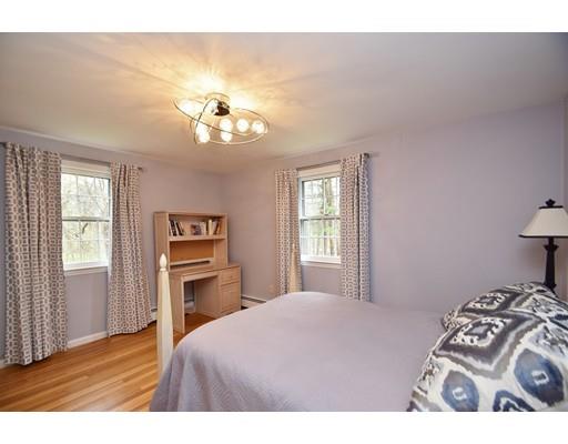 180 Rowley Bridge Road Topsfield, MA 01983 - Photo 20 of 30 a bedroom with a bed and a chandelier