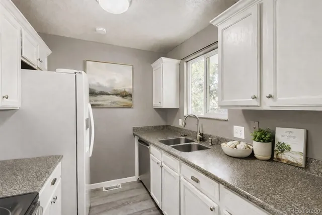 a kitchen with stainless steel appliances granite countertop a refrigerator sink and stove