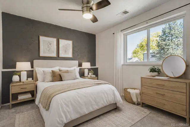 a bedroom with a bed and a dresser next to a window