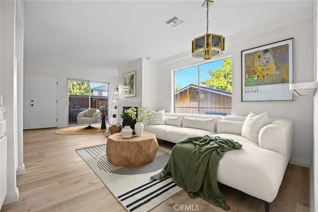 a living room with furniture a window and a flat screen tv