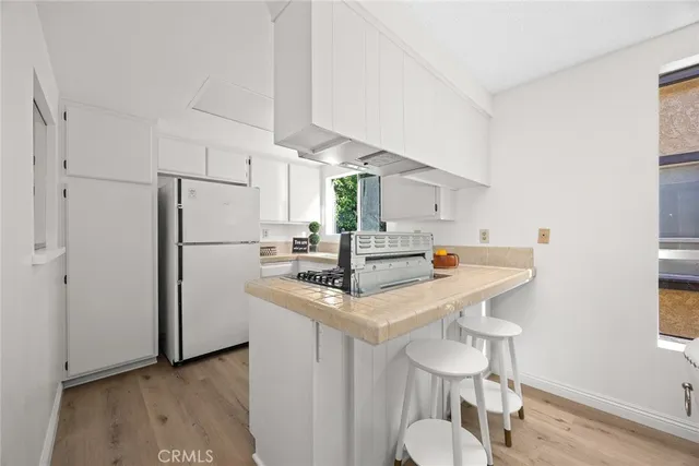 a kitchen with stainless steel appliances a table chairs and a refrigerator