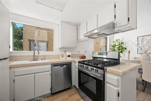a kitchen with stainless steel appliances a sink stove and cabinets