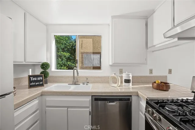 a kitchen with sink a stove and cabinets